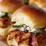 Delicious BBQ chicken sliders served on a platter with fresh toppings
