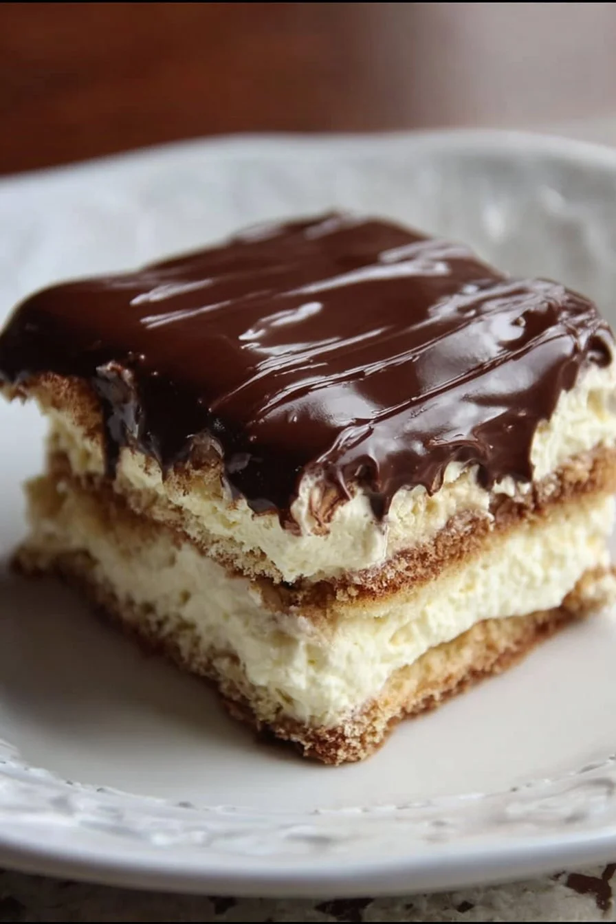 Delicious Eclair Icebox Cake topped with chocolate and whipped cream