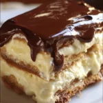 No Bake Éclair Cake topped with chocolate icing and whipped cream