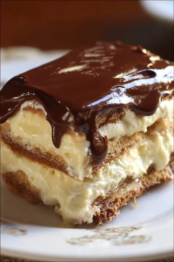 No Bake Éclair Cake topped with chocolate icing and whipped cream