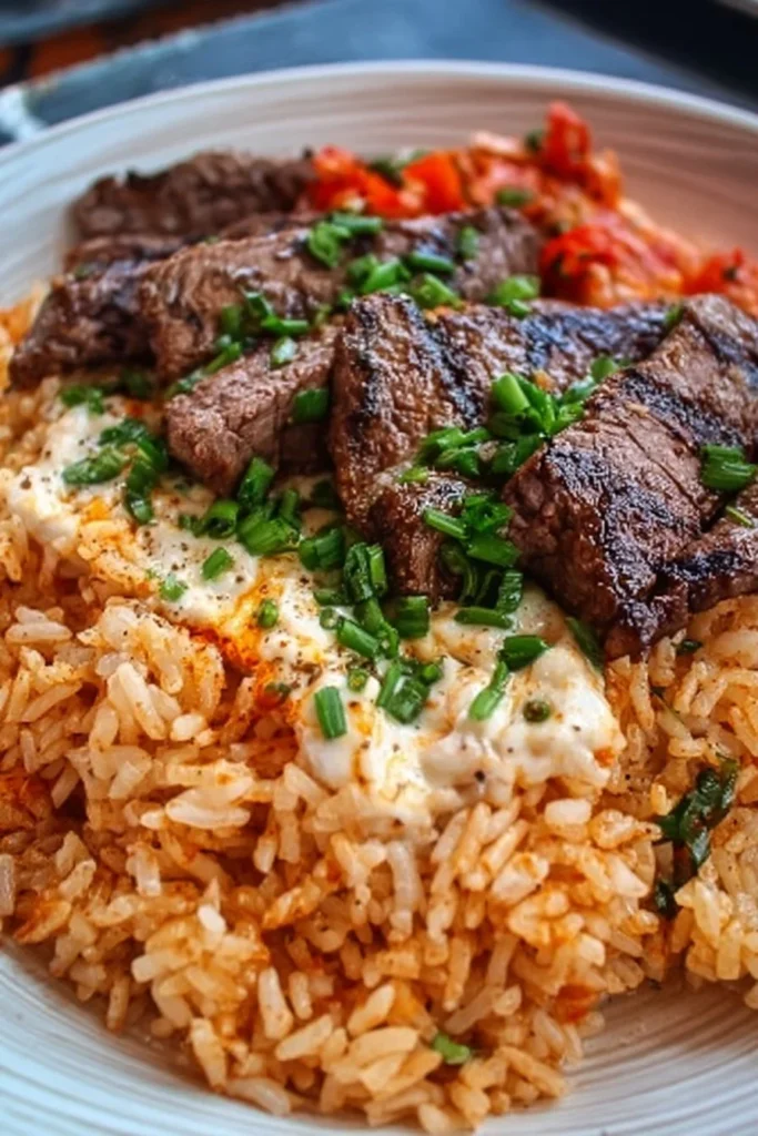 Delicious Steak & Cheese Rice served with fresh vegetables and herbs