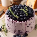 Fluffy blueberry chiffon cake topped with fresh blueberries and whipped cream.