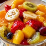 Easter Fruit Salad topped with peach pie filling in a decorative bowl.