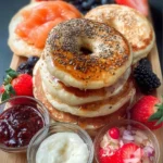 Fluffy pancakes stacked on a plate with syrup and berries