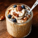 Bowl of creamy overnight oatmeal topped with fresh fruits and nuts