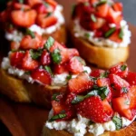 Delicious strawberry ricotta bruschetta topped with fresh strawberries on toasted bread