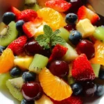 A colorful bowl of fresh fruit salad with various sliced fruits.